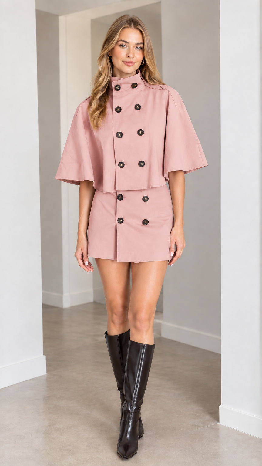 Model wearing dusty pink high-neck cape jacket and matching mini skirt set