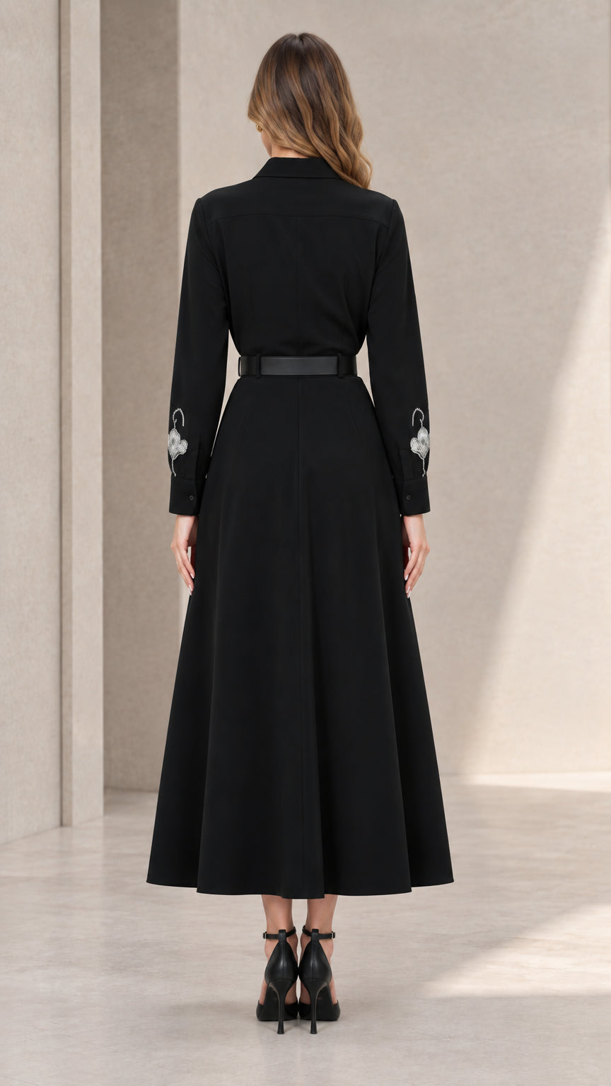Back view of black long sleeve collared midi dress with belt