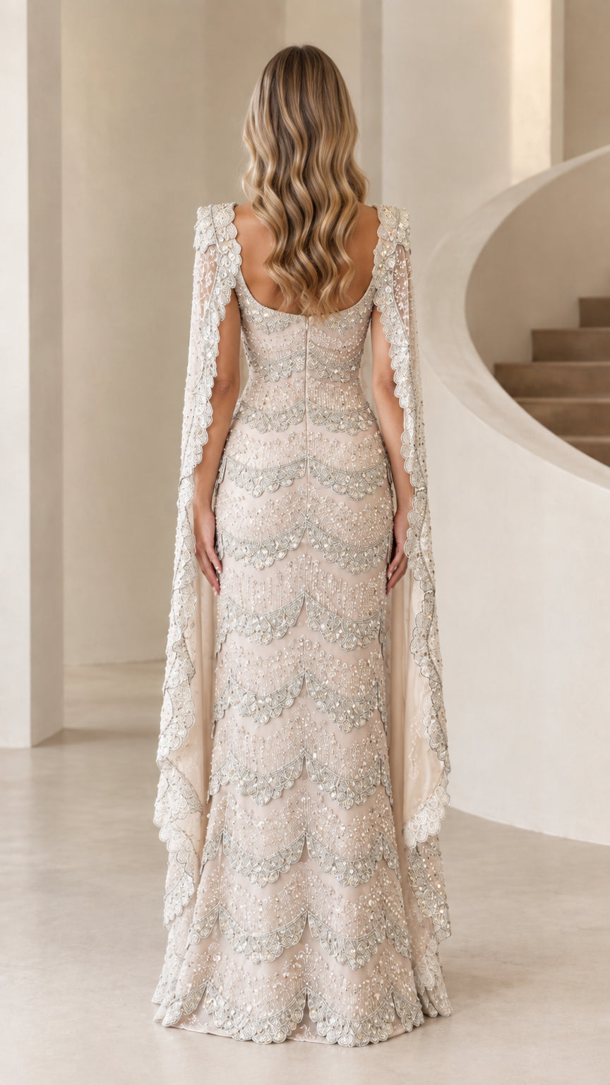Back view of model wearing champagne beaded evening dress with matching capelet
