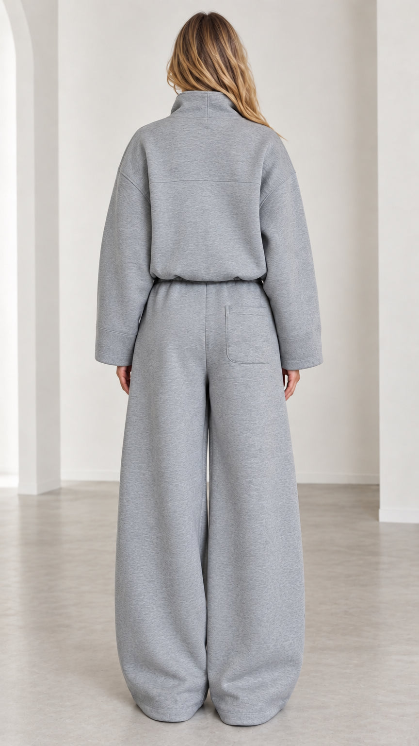 Back view of women's heather gray two-piece tracksuit with pocket detail