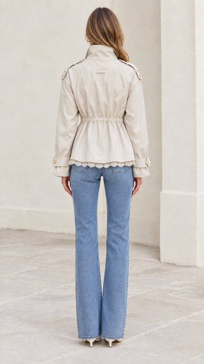 Back view of model wearing beige utility jacket highlighting elastic gathered waistline
