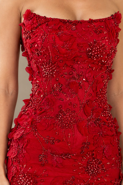 Close-up detail of 3D floral appliqués and beaded embroidery on red bodice