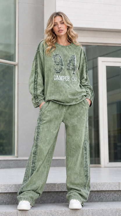 Full-length front view of sage green mineral washed graphic tracksuit set with wide leg pants
